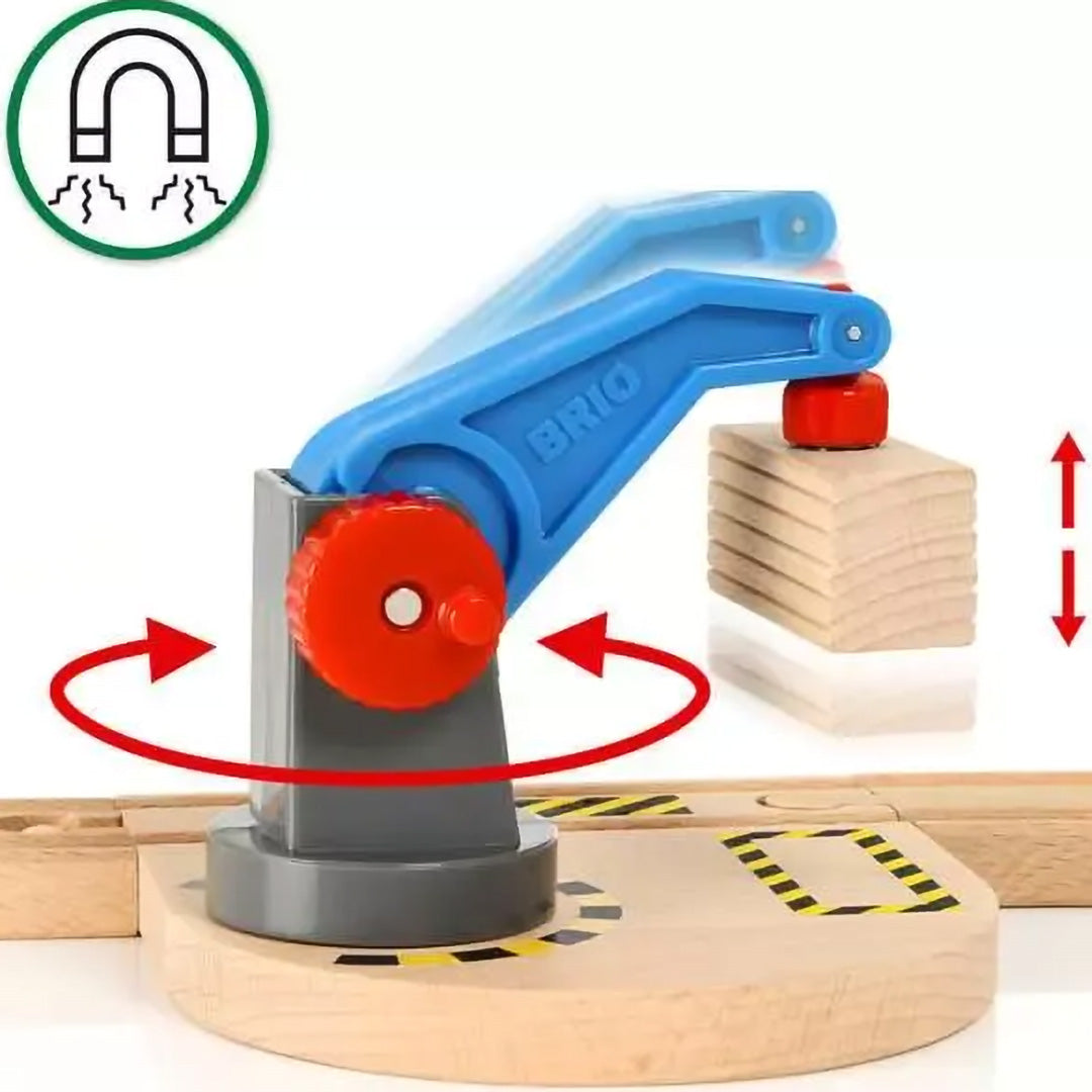 Detail van de blauwe Brio speelgoedkraan die met een magneet houten blokken optilt, met pijlen die de draai- en liftfunctie aangeven.