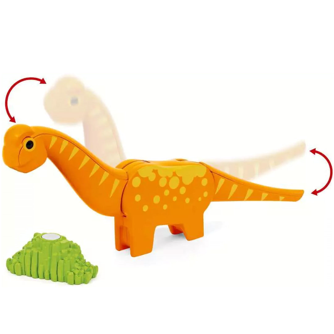 Oranje speelgoed dinosaurus met beweegbare kop en staart, naast een groene struik.