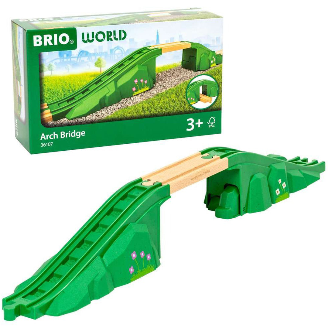 Brio houten en plastic boogbrug voor speelgoedtreinen, met groene hellingen en bloemdecoraties, naast de productverpakking.