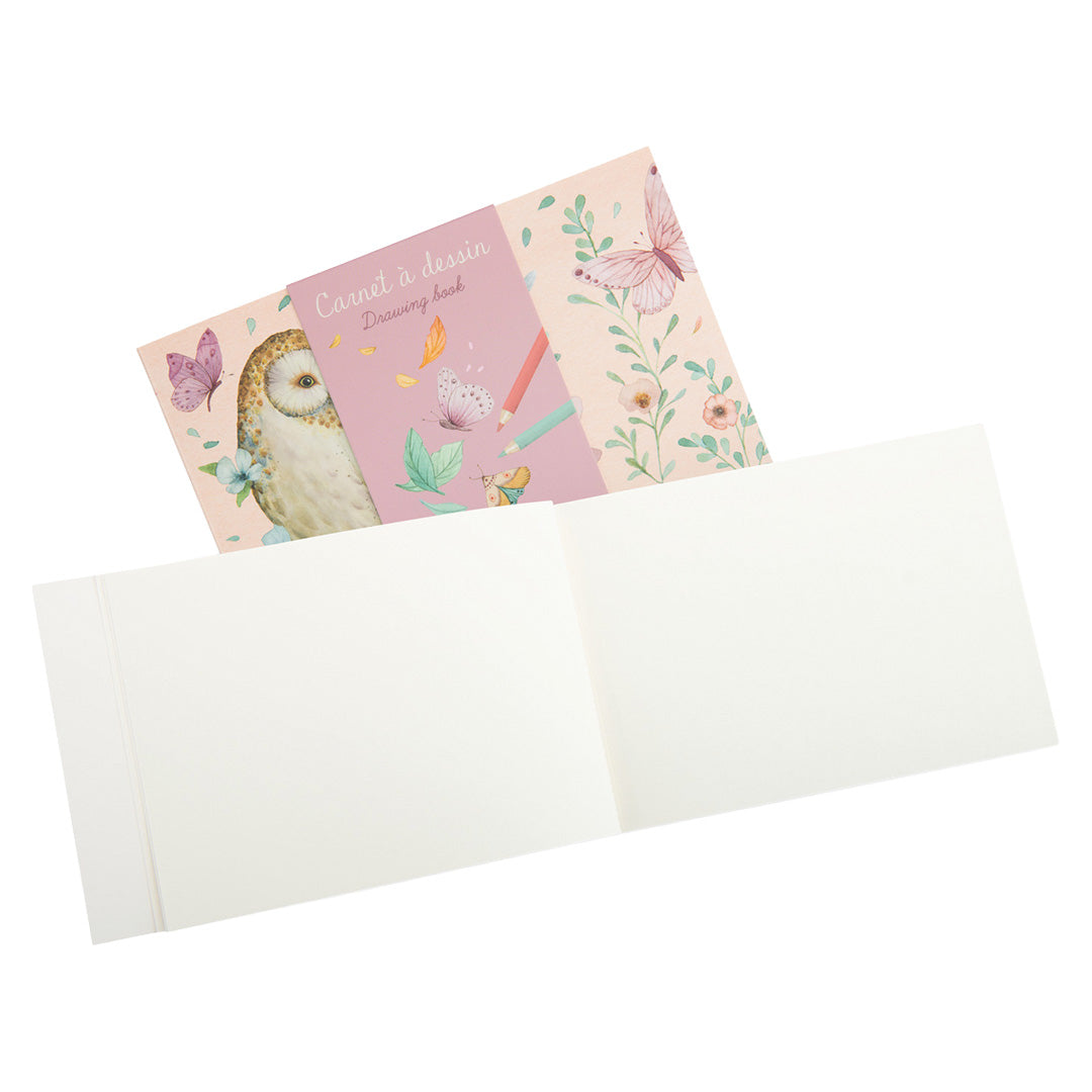 Open Moulin Roty schetsboek met blanco pagina's en de roze kaft met uil en vlinders.