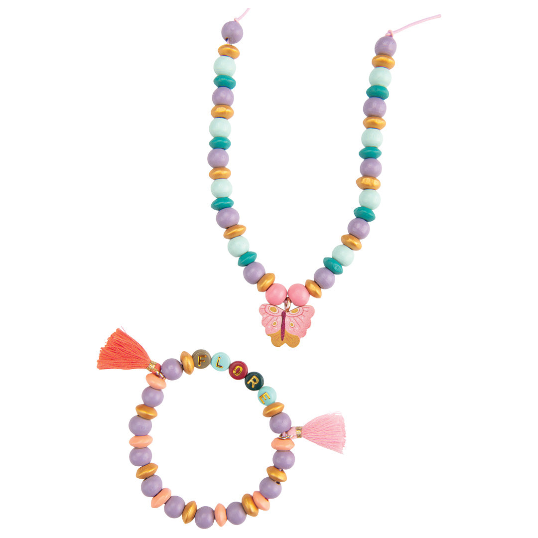 Een gemaakte houten kralenketting met vlinder en een armband met letterkralen en kwastjes.