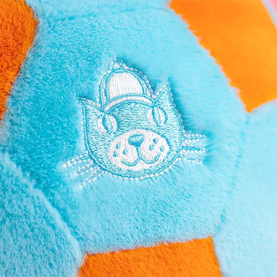 Detail van de turquoise pluche stof van de knuffelbal met een geborduurd kattenhoofdlogo.