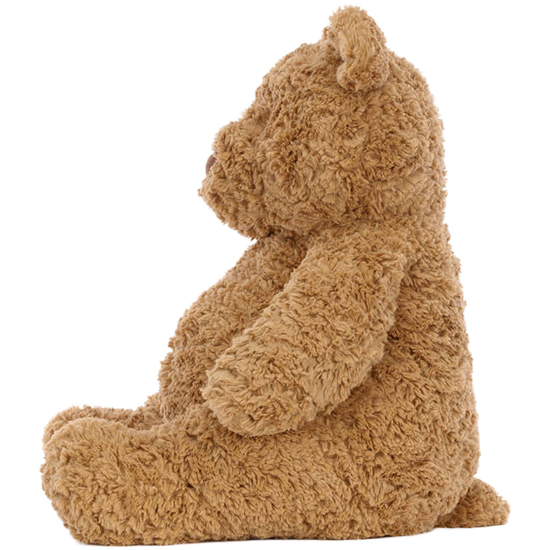 Zijaanzicht van de bruine Jellycat knuffelbeer Bartholomew Huge, zittend.