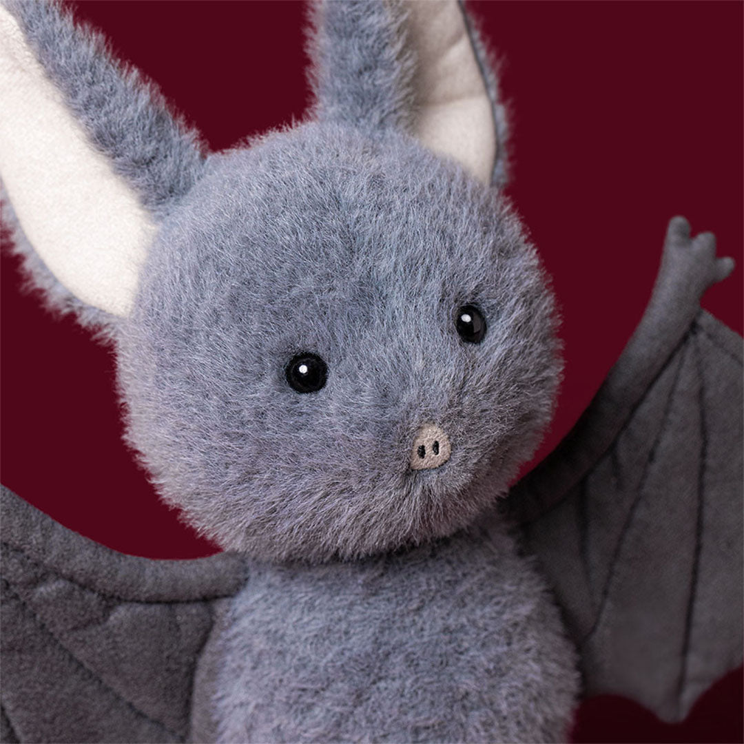 Detailopname van het gezicht van de Jellycat pluchen vleermuis met grote oren.
