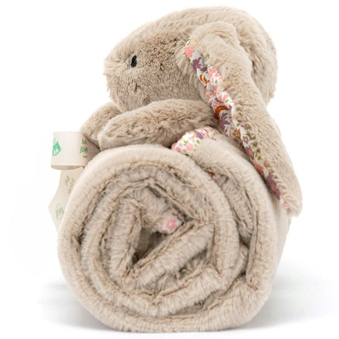 Zijaanzicht van het opgerolde Jellycat knuffeldekentje met een beige konijn en lint.