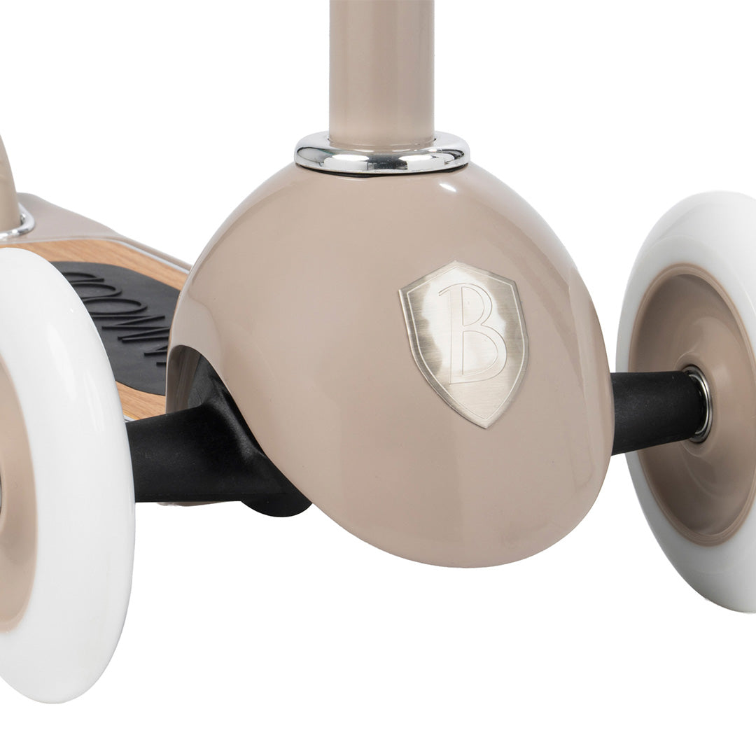 Detail van de twee voorwielen en de beige basis van de Banwood kinderstep met het merklogo.