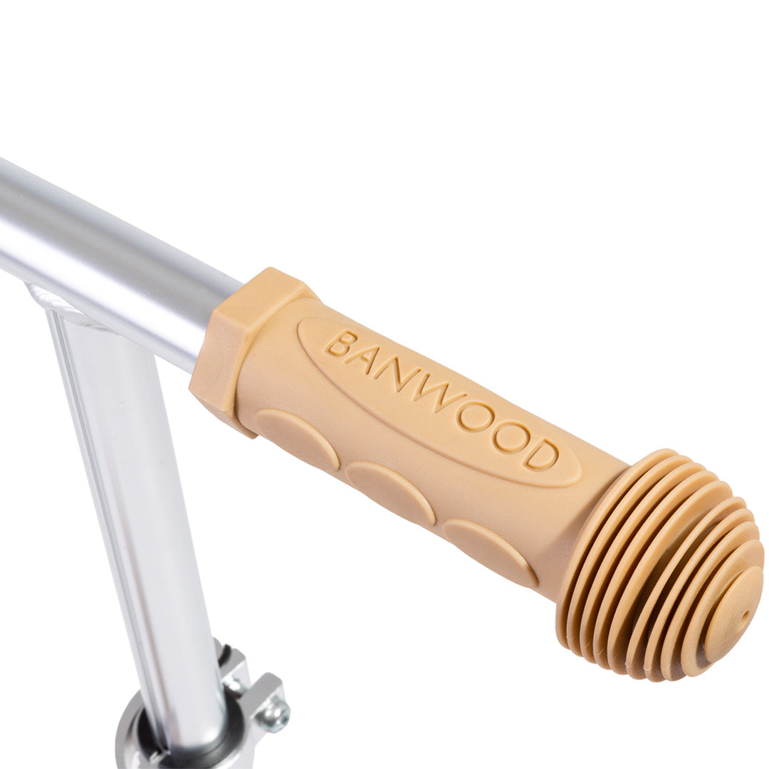Detail van het lichtbruine handvat van een Banwood kinderstep met het merklogo.