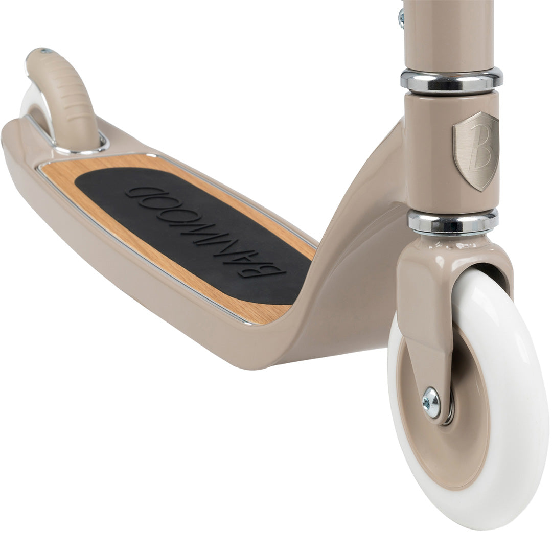 Detail van de Banwood beige kinderstep met het voorwiel en de houten voetenplank met antislip.