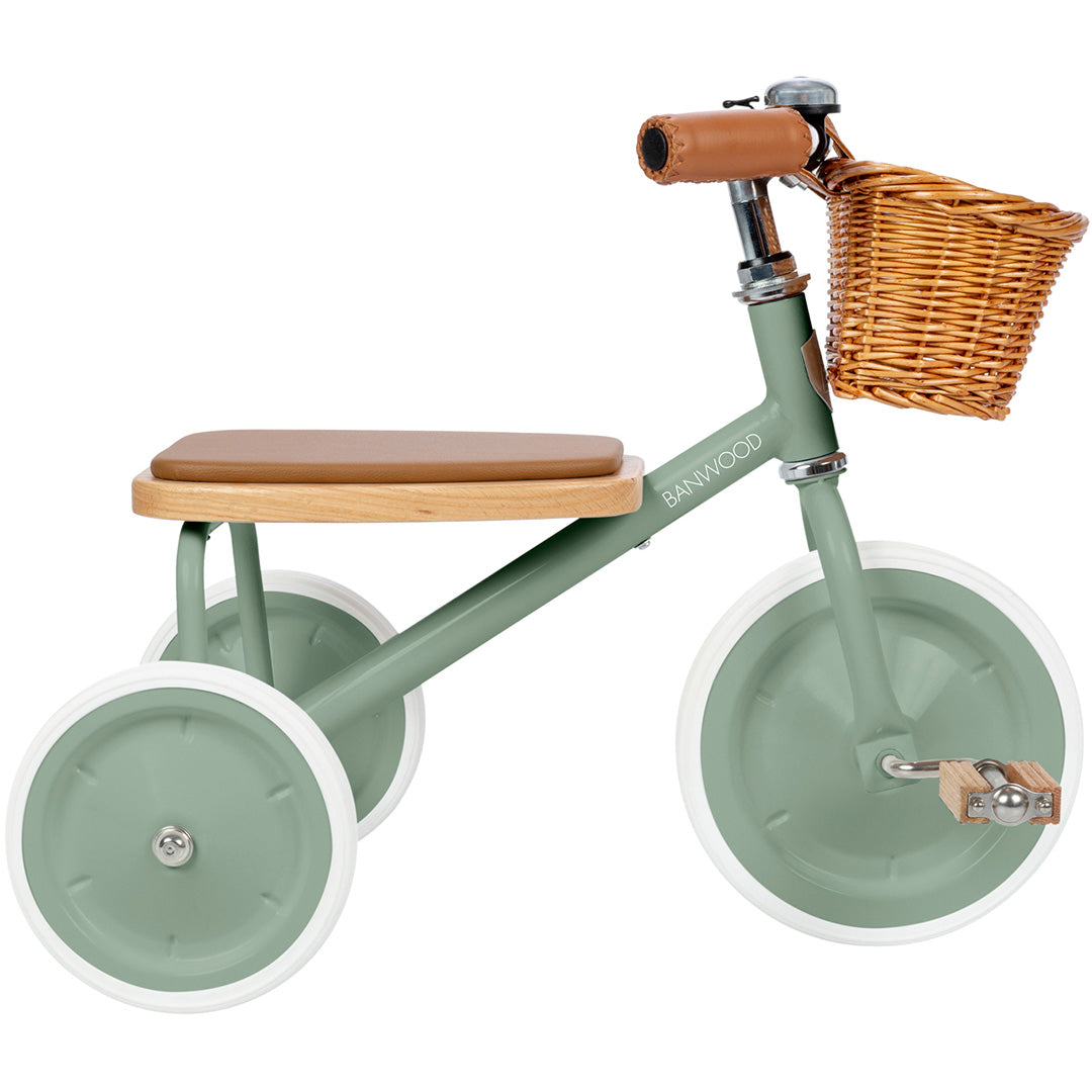Banwood driewieler in de kleur groen met een rieten mandje en bruin zadel.