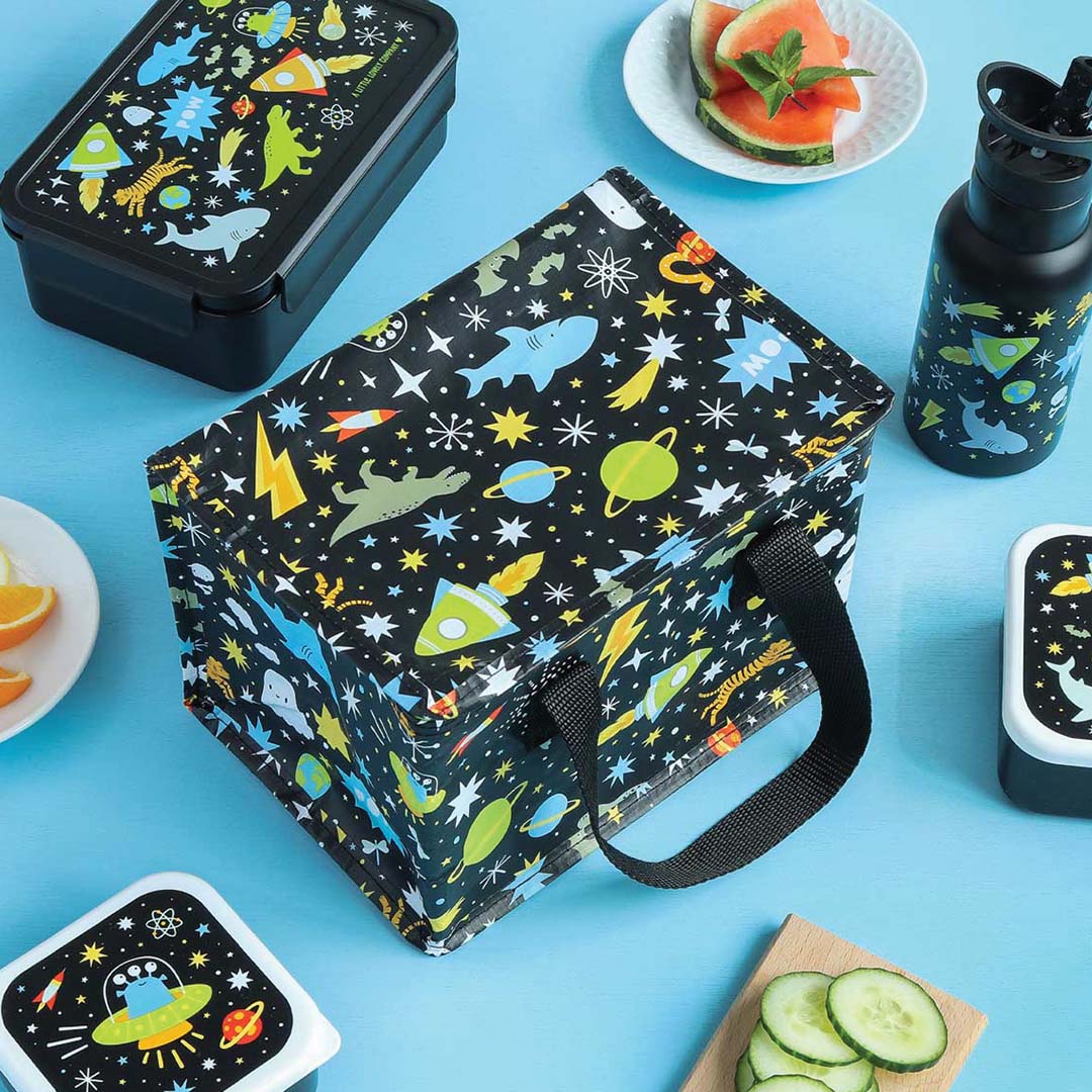 a little lovely company koeltas met galaxy patroon, omringd door bijpassende lunchboxen en een drinkfles.