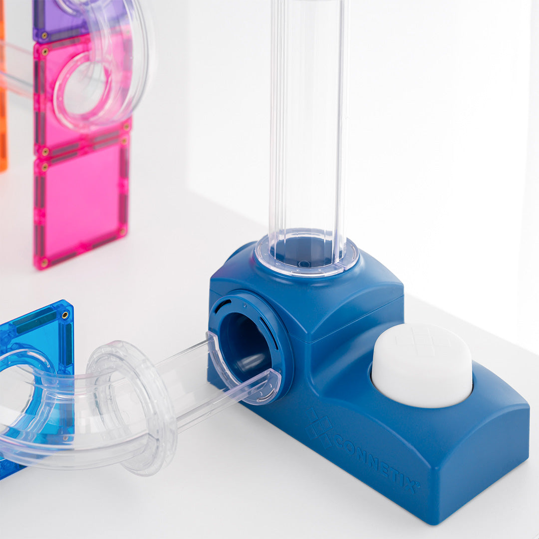 Detailopname van de blauwe lanceerbasis van de Connetix knikkerbaan met een transparante buis.