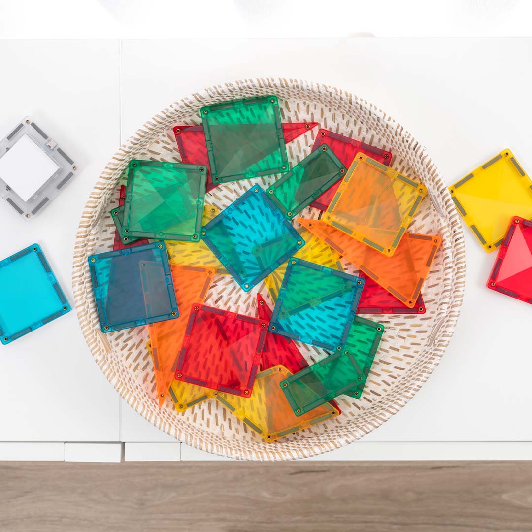 Een mand vol kleurrijke Connetix magnetische tegels, van bovenaf gezien.