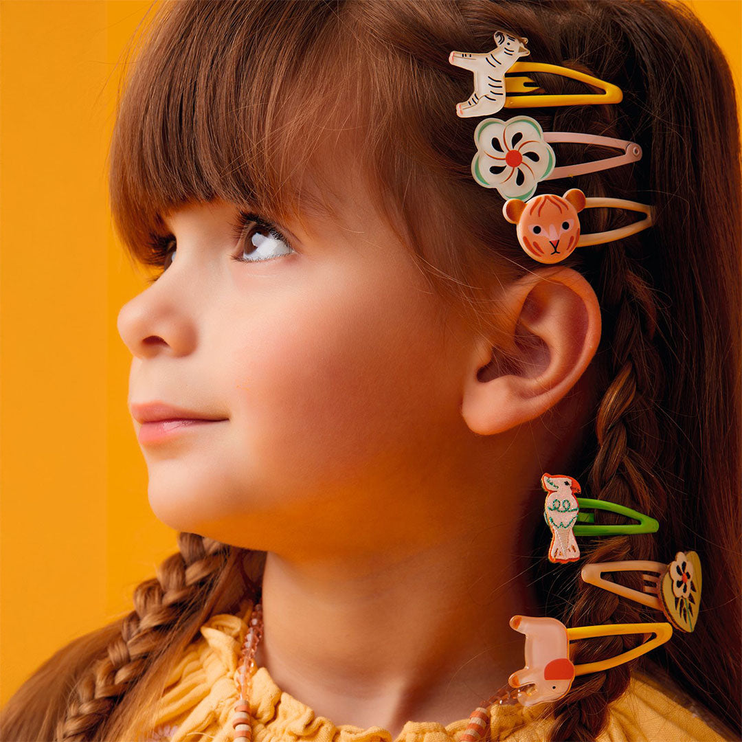 Een meisje met Djeco haarspeldjes met dieren- en bloemmotieven in haar haar.
