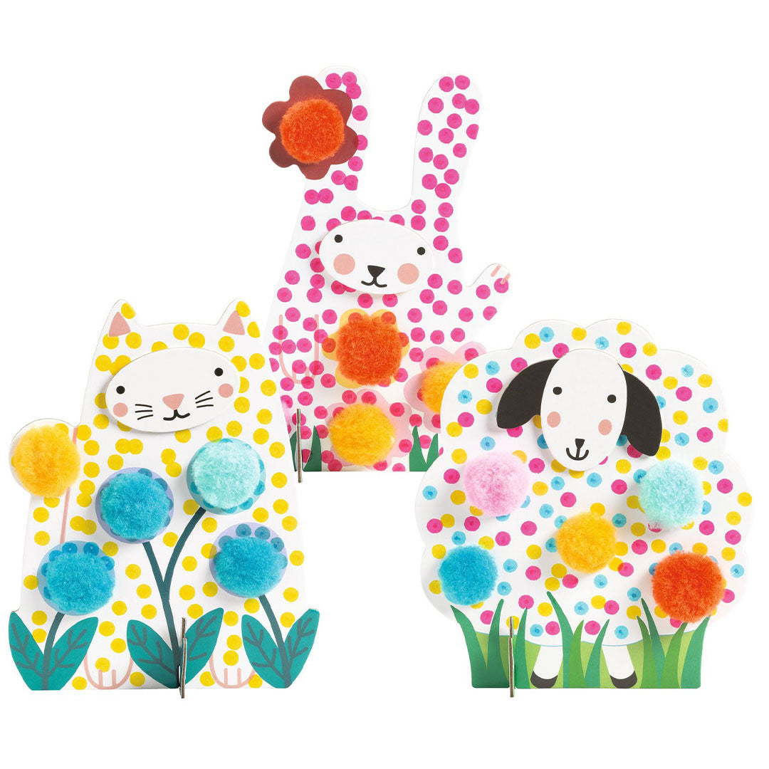 Drie versierde dierenfiguren van een konijn, kat en schaap met kleurrijke pompoms.