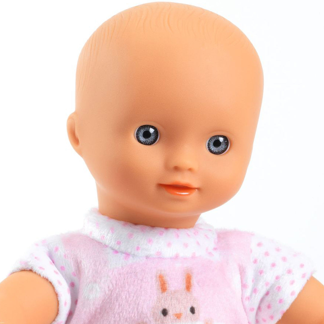 Close-up van het gezicht van de babypop Mini Poppy met roze pakje met konijn.