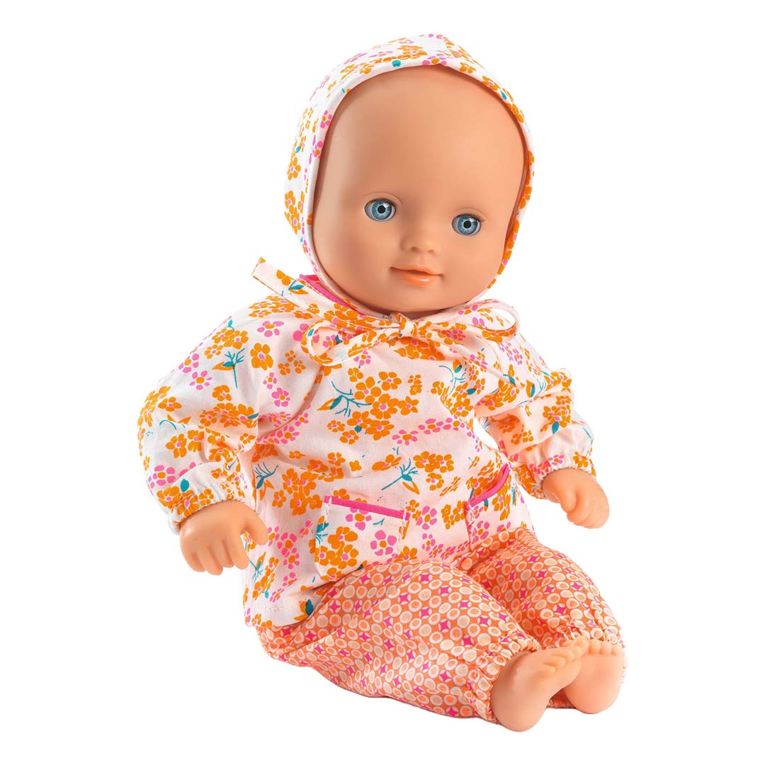 Djeco pop met blauwe ogen draagt de gebloemde poppenkledingset Pomea en zit op de grond.