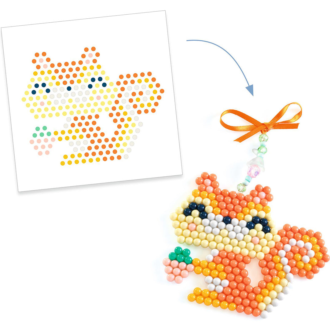 Een sjabloon voor een eekhoorn van waterkralen naast het afgewerkte eekhoornfiguur met oranje lint.