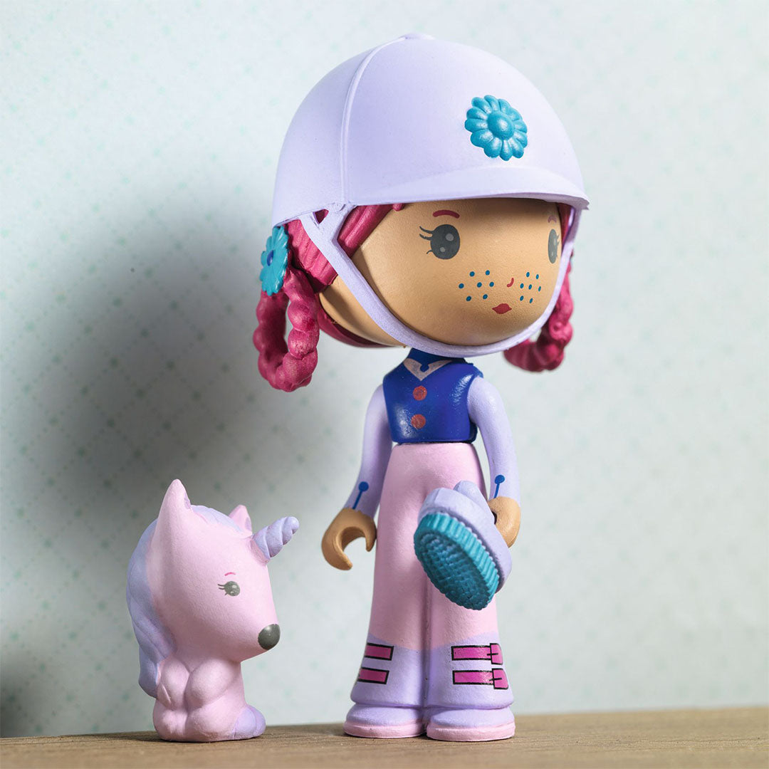 Djeco Tinyly speelfiguur Joe met witte paardrijhelm en borstel, naast een roze eenhoorn.