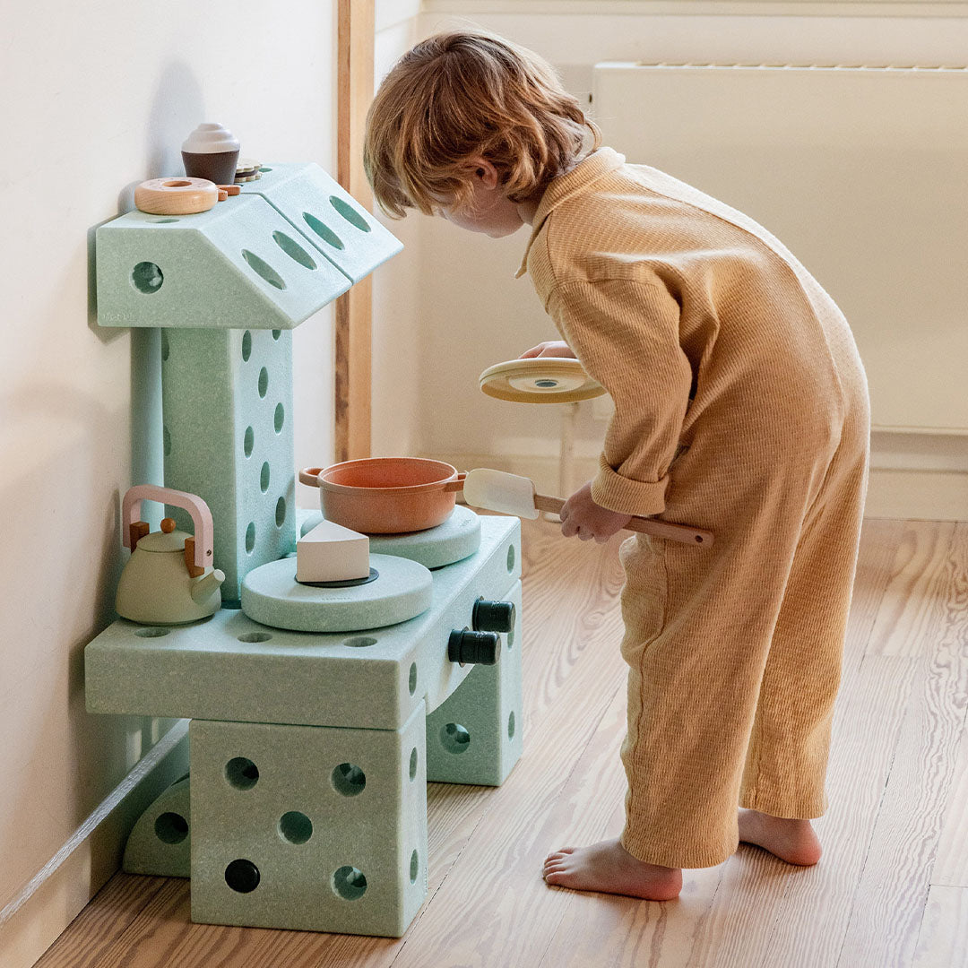 Een kind speelt met een speelkeuken gemaakt van Modu schuimrubberblokken in ocean mint kleur.