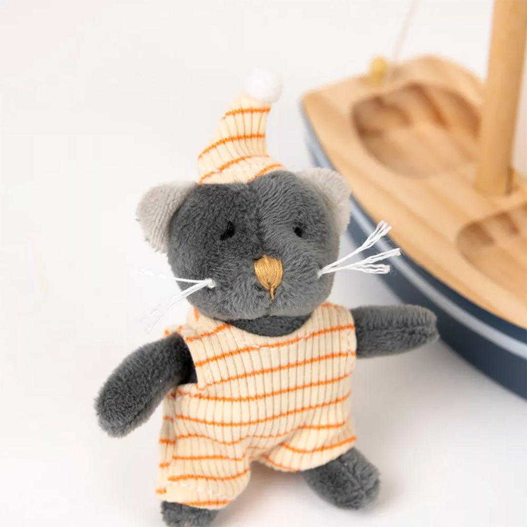 Detailfoto van de grijze knuffelkat met gestreepte oranje-witte kleding en slaapmuts.