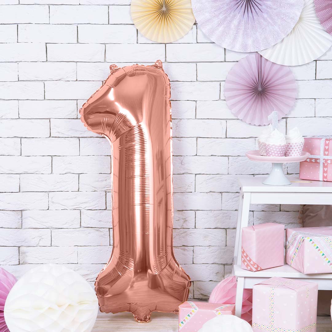 Partydeco roségouden cijferballon 1 als verjaardagsdecoratie in een kamer met cadeaus.