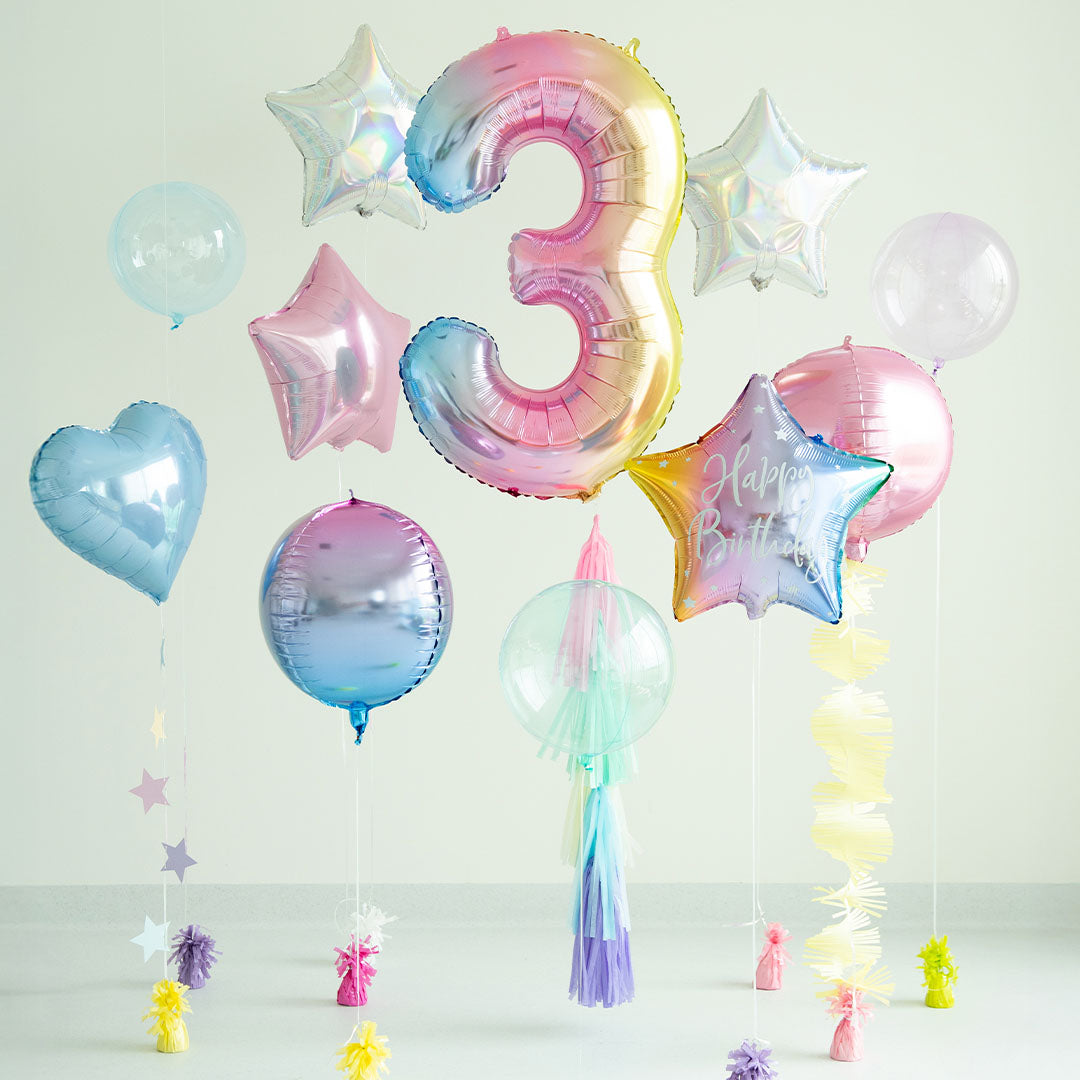 Een collectie Partydeco feestballonnen in pastel regenboogkleuren, inclusief een cijferballon 3, sterren en harten, als verjaardagsdecoratie.
