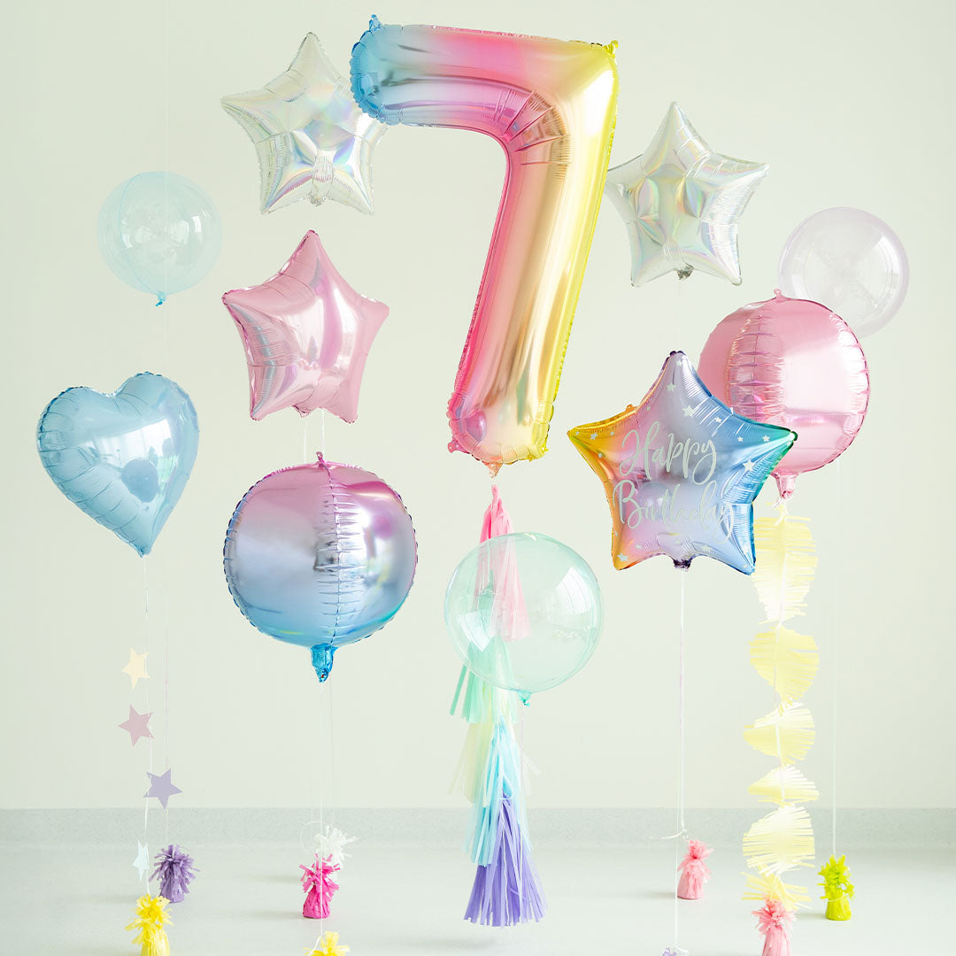 Een feestelijke opstelling met diverse pastelkleurige ballonnen, waaronder een cijferballon 7, sterren en harten, en bijpassende slingers.