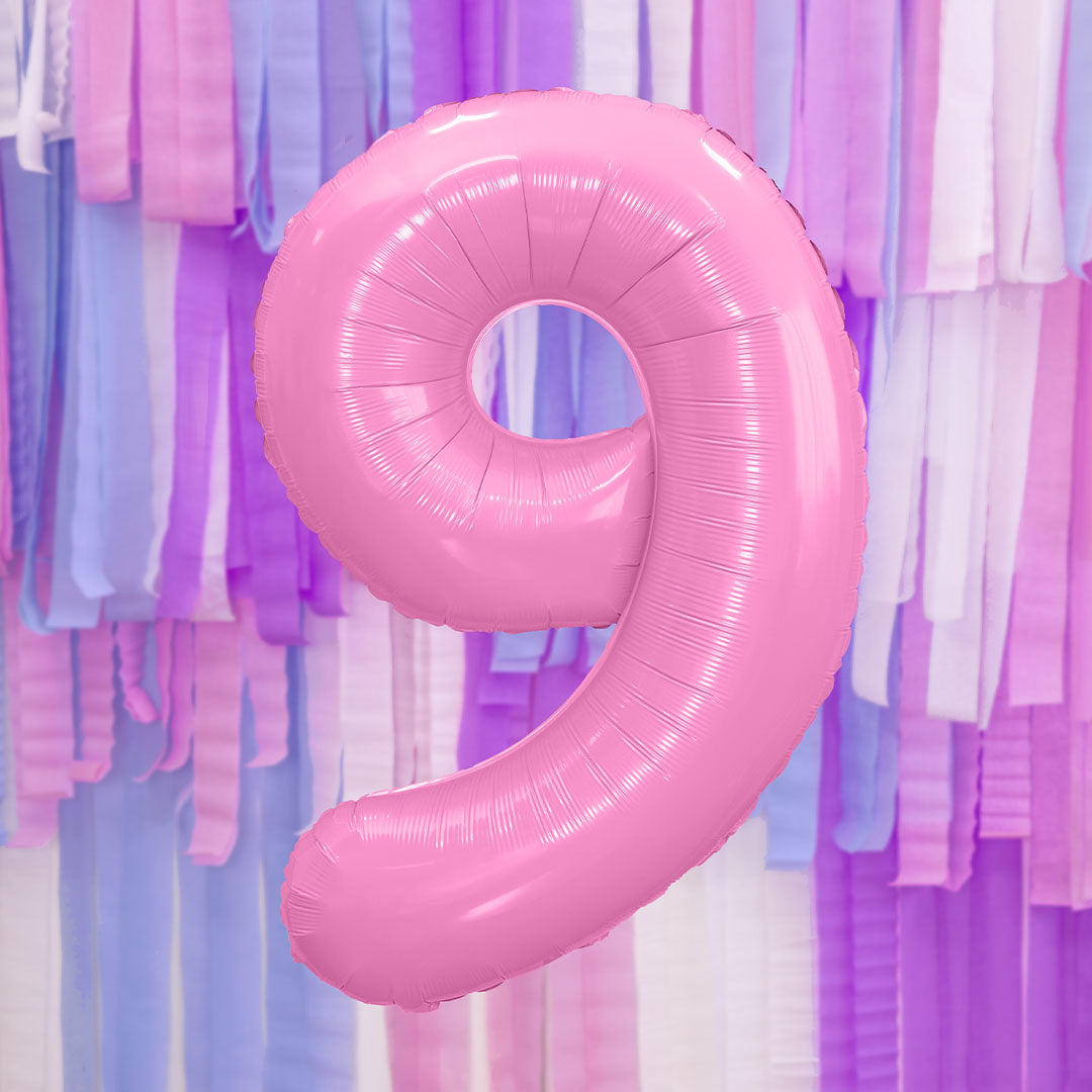 PartyDeco roze folieballon cijfer 9 zwevend voor een achtergrond van feestelijke slingers.