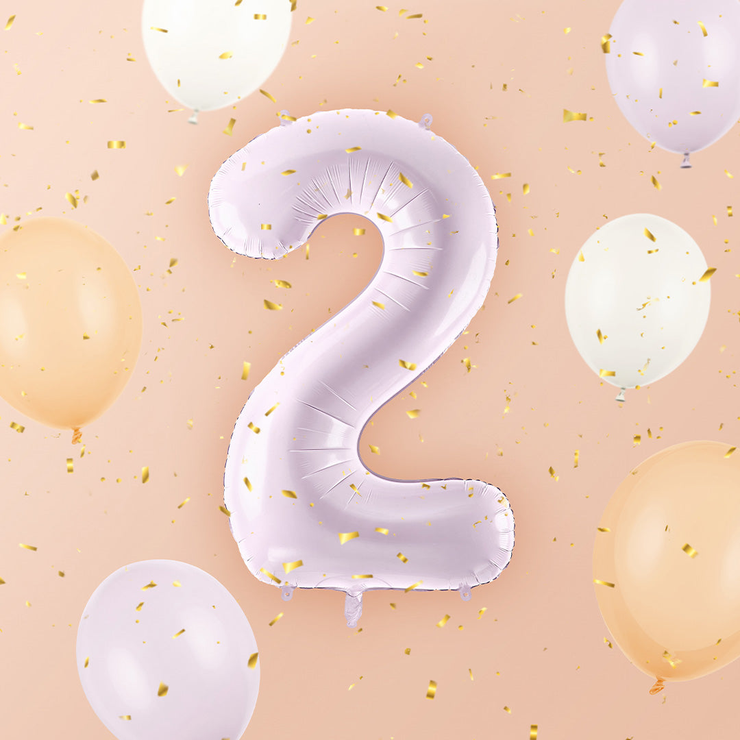 Partydeco paarse cijferballon nummer 2 zwevend tussen kleinere ballonnen en gouden confetti.