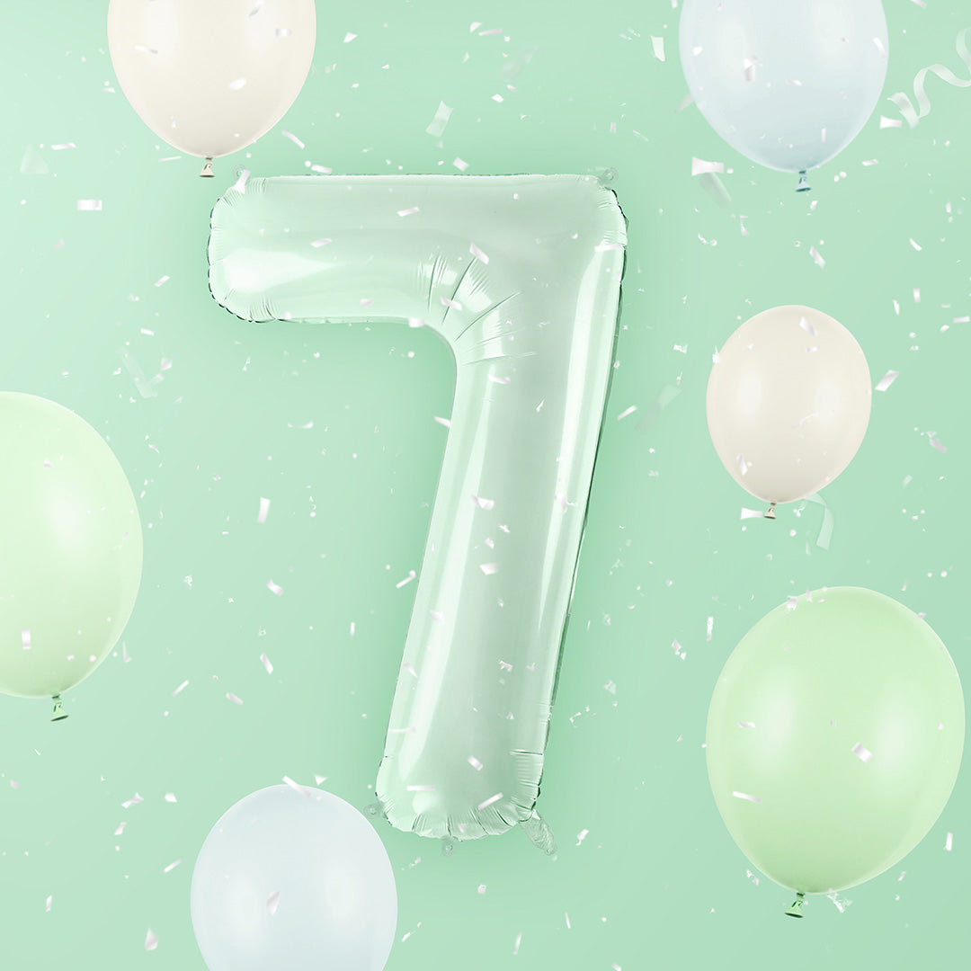Partydeco cijferballon 7 in lichtgroen, zwevend tussen andere pastelkleurige ballonnen en confetti tegen een groene achtergrond.