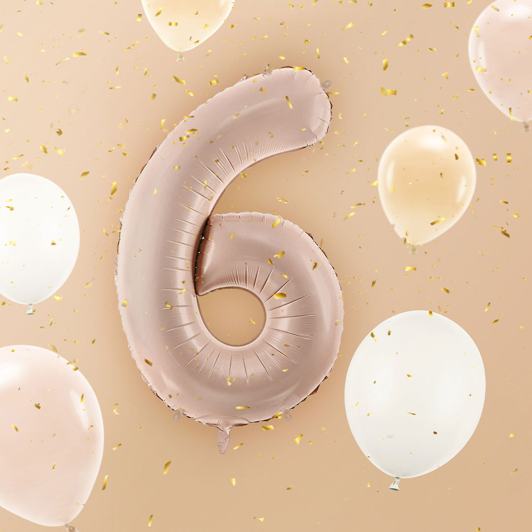 Donker beige cijferballon 6 zweeft tussen witte en beige ballonnen met gouden confetti.
