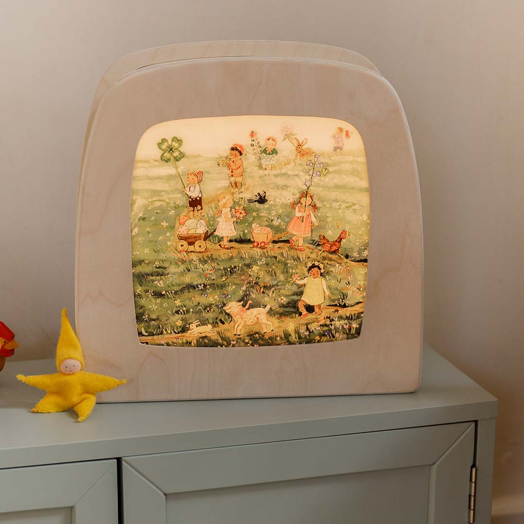 Toverlux toverplaat met lenteparade illustratie verlicht in een houten toverlamp op een kastje.