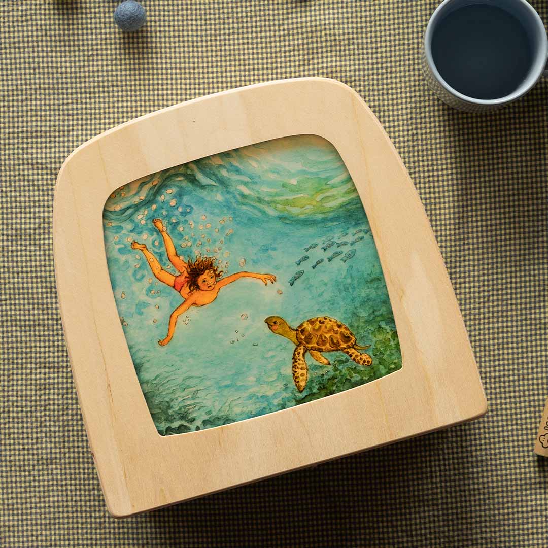 Toverlux toverplaat met een illustratie van een kind en een schildpad onder water, liggend op een geruite doek.