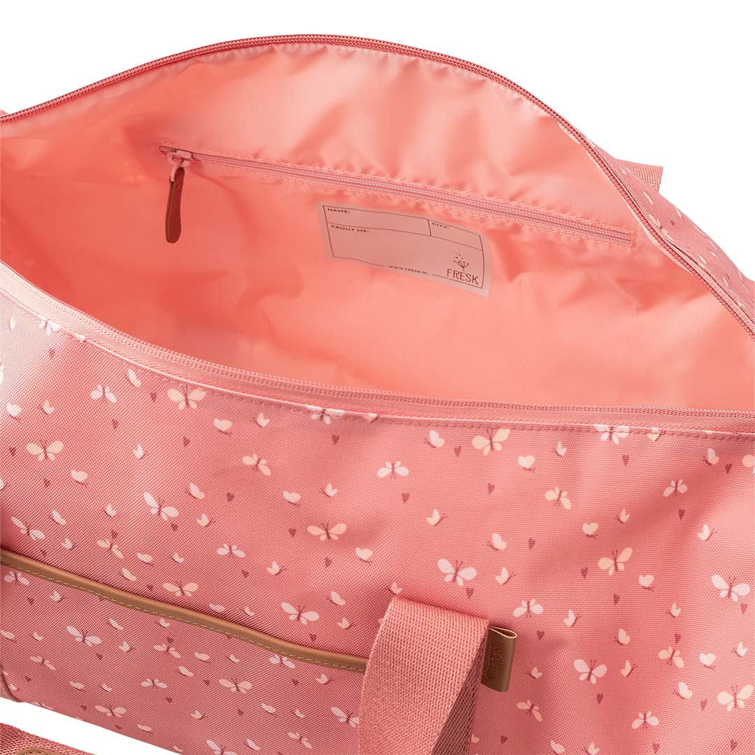 De open Fresk roze kinder weekendtas met vlinderpatroon, met zicht op de binnenkant en een naamlabel.