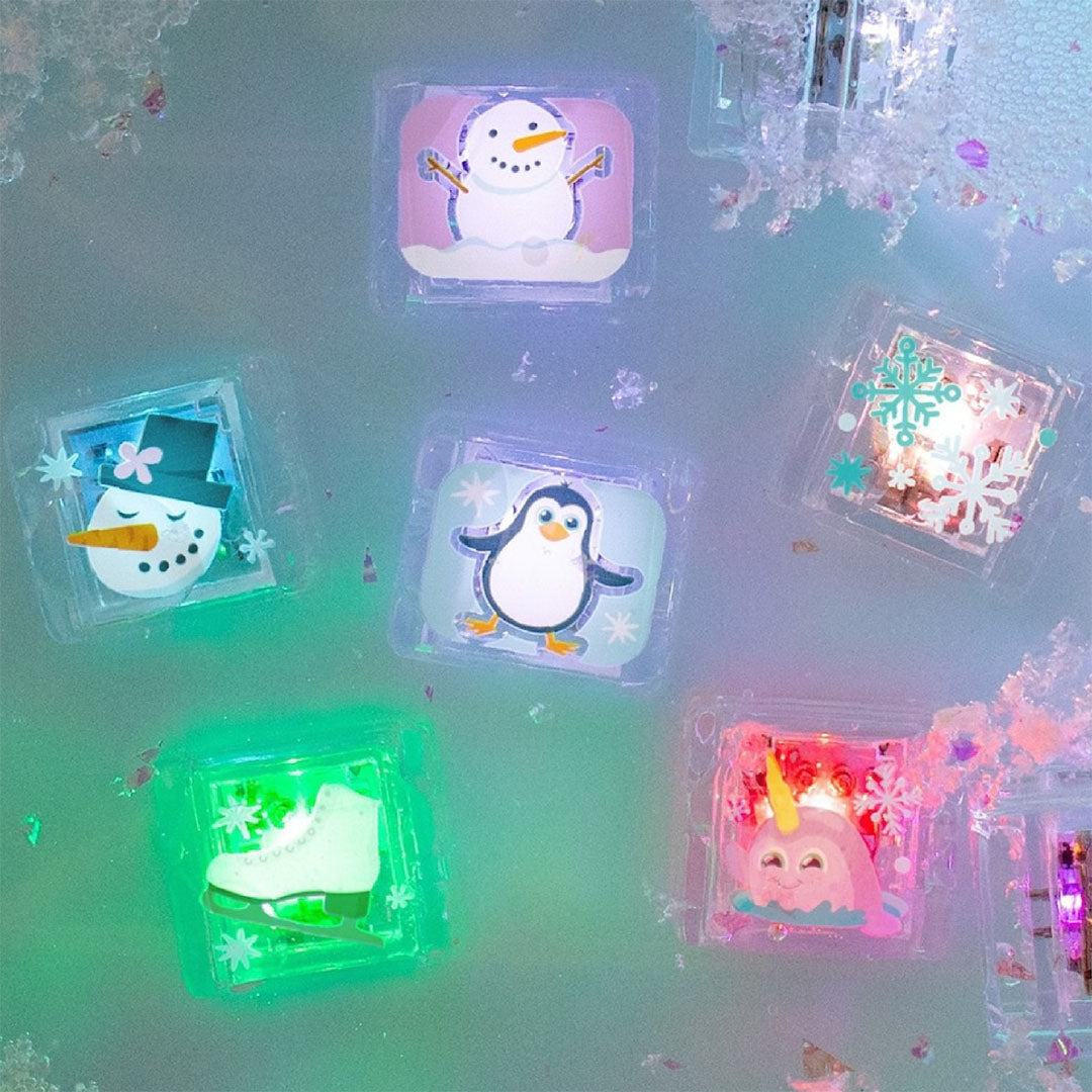 Zes oplichtende winter badspeelgoedblokjes met figuren zoals een sneeuwpop en pinguïn, drijvend in water.