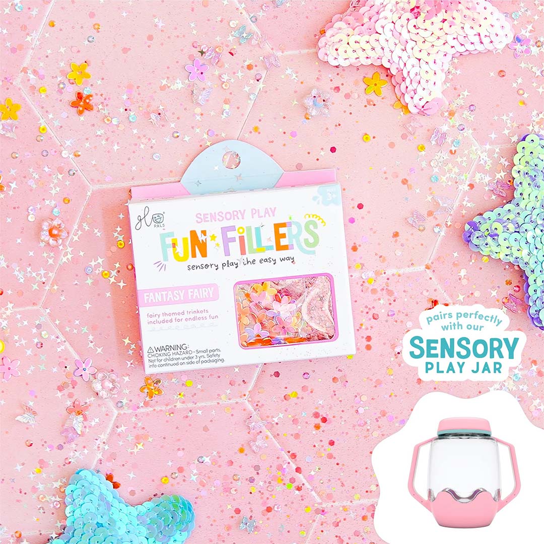De verpakking van glo pals Fun Fillers Fantasy Fairy sensorisch speelgoed ligt op een roze ondergrond met bloemvormige glitters en decoraties.