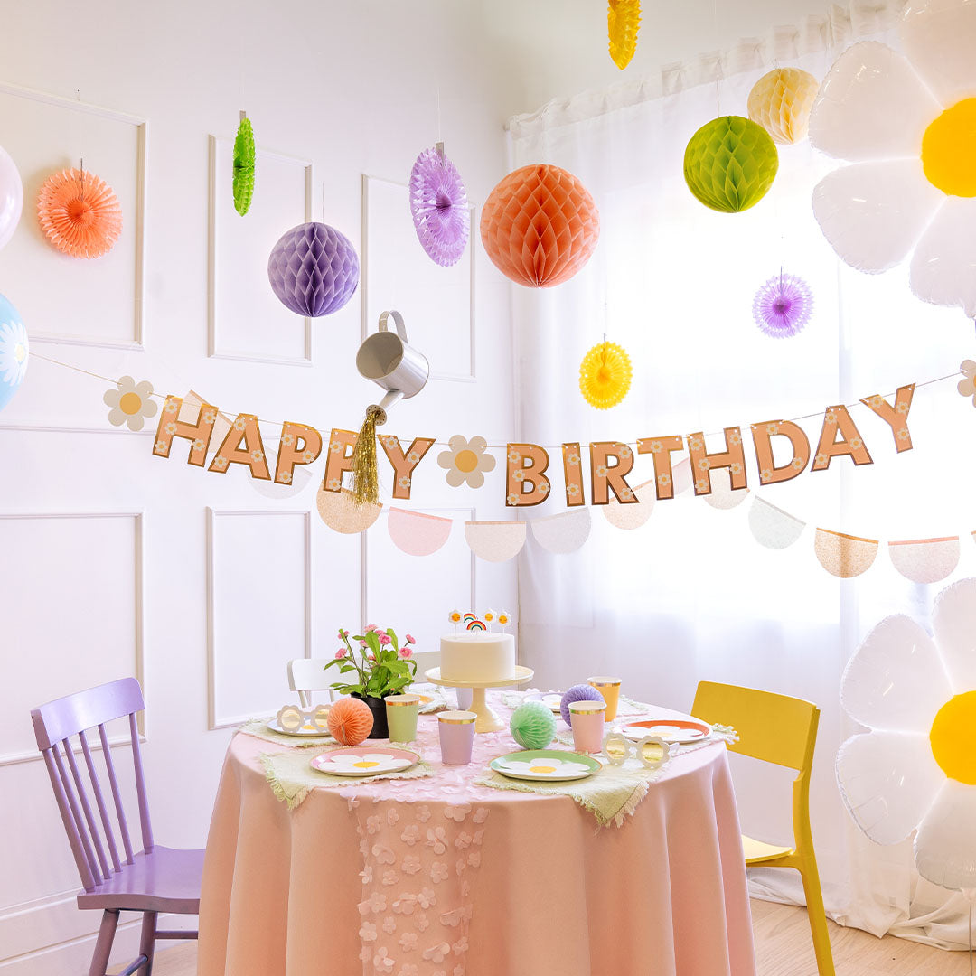 Een feestelijk versierde kamer met de PartyDeco Happy Birthday slinger boven een gedekte tafel.