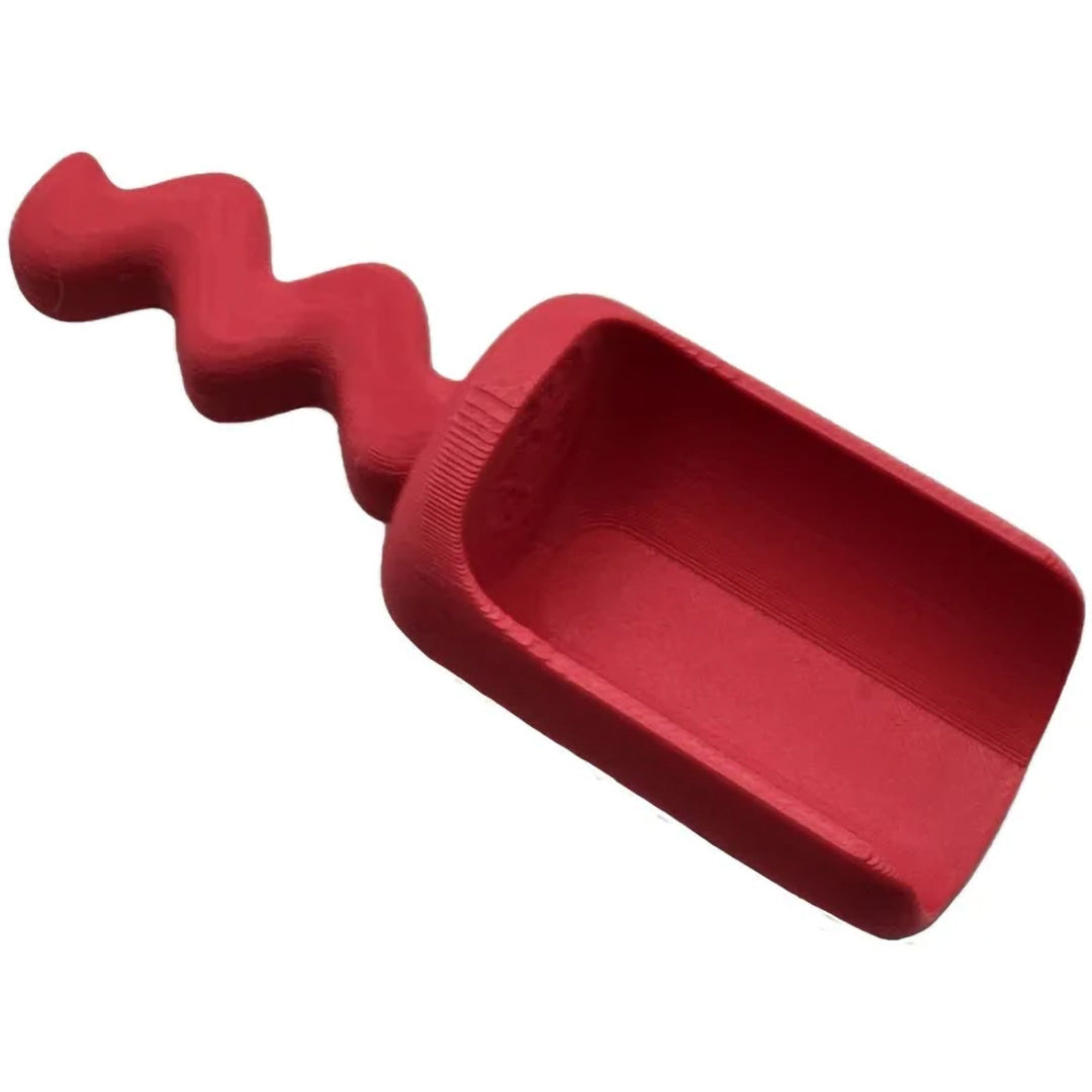 Een rood grennn speelschepje met een golvend handvat.