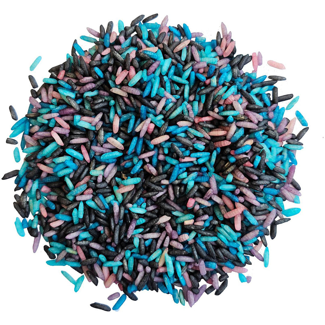 grennn speelrijst galaxy mix, een hoopje gekleurde rijstkorrels in roze, blauw, paars en zwart.