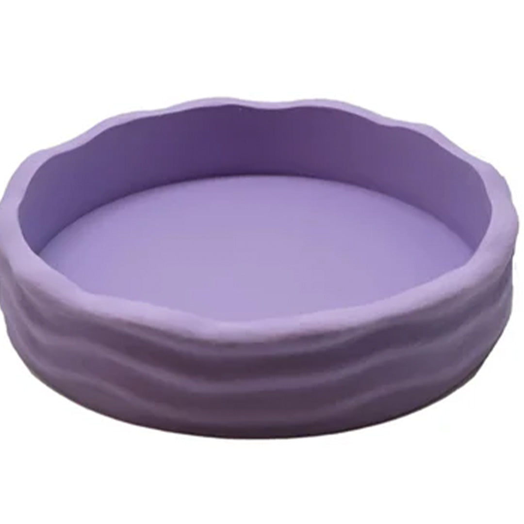 Grennn ronde pastel paarse speelbak met golvende textuurrand.