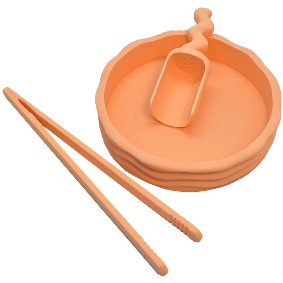 Een grennn set sensorisch speelgoed met een pastel oranje bamboe pincet, kom en schepje.