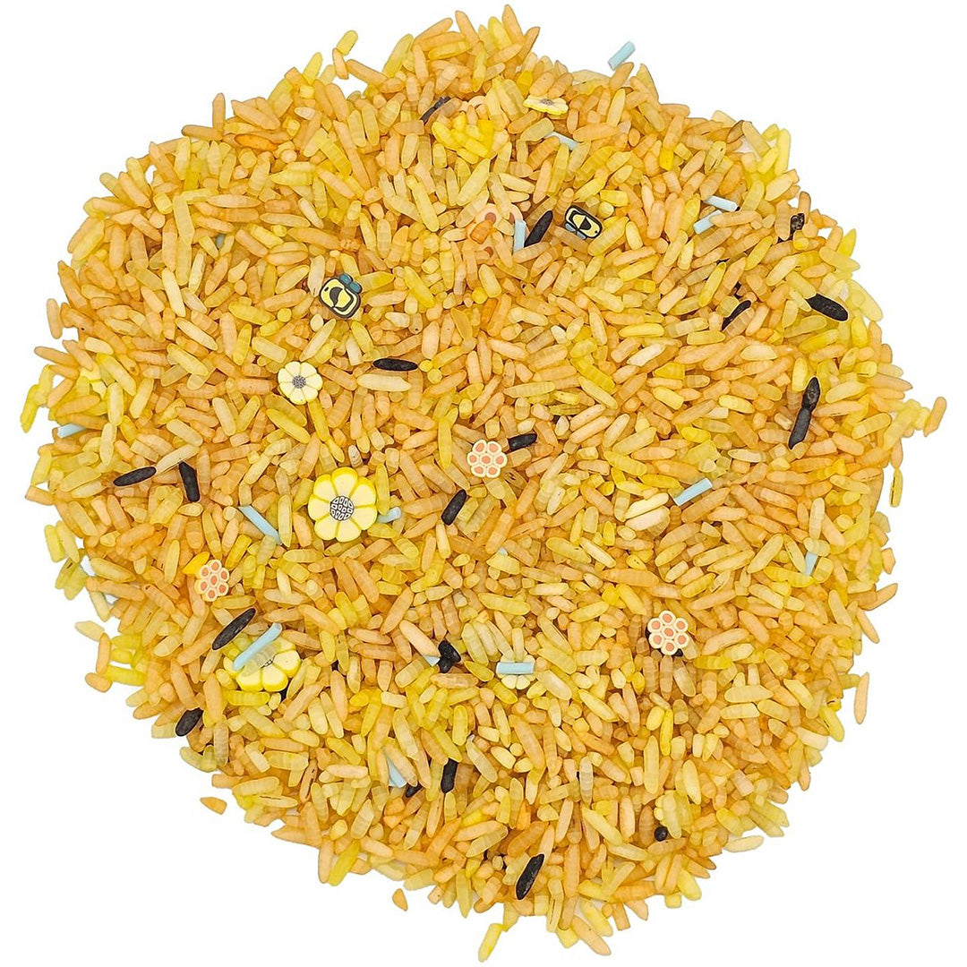Bovenafbeelding van grennn speelrijst bijenmix, een hoop gele rijst met kleine bijen, bloemen en honingraatjes.