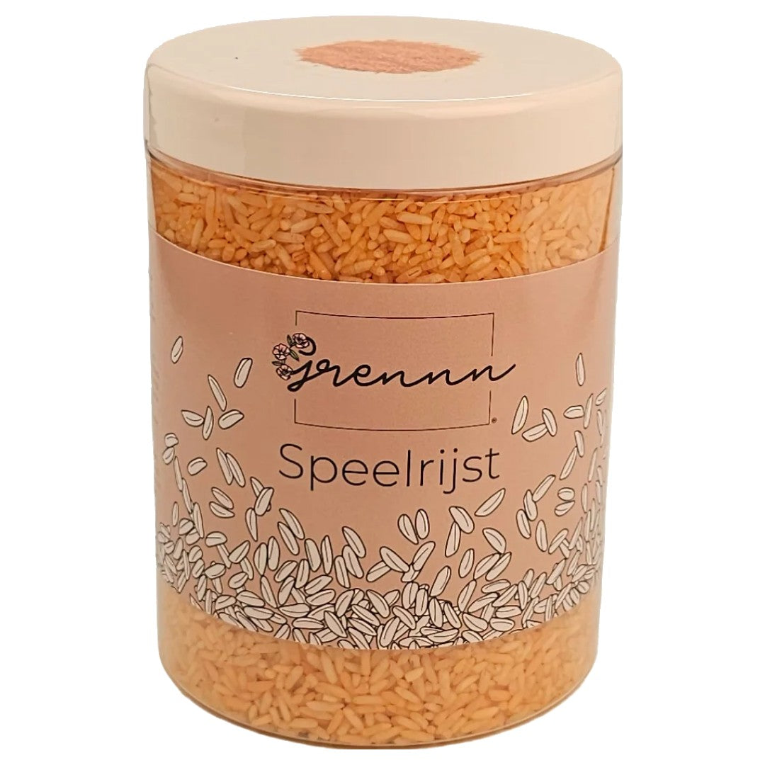 Verpakking van grennn oranje speelrijst in een transparante pot met roze etiket.