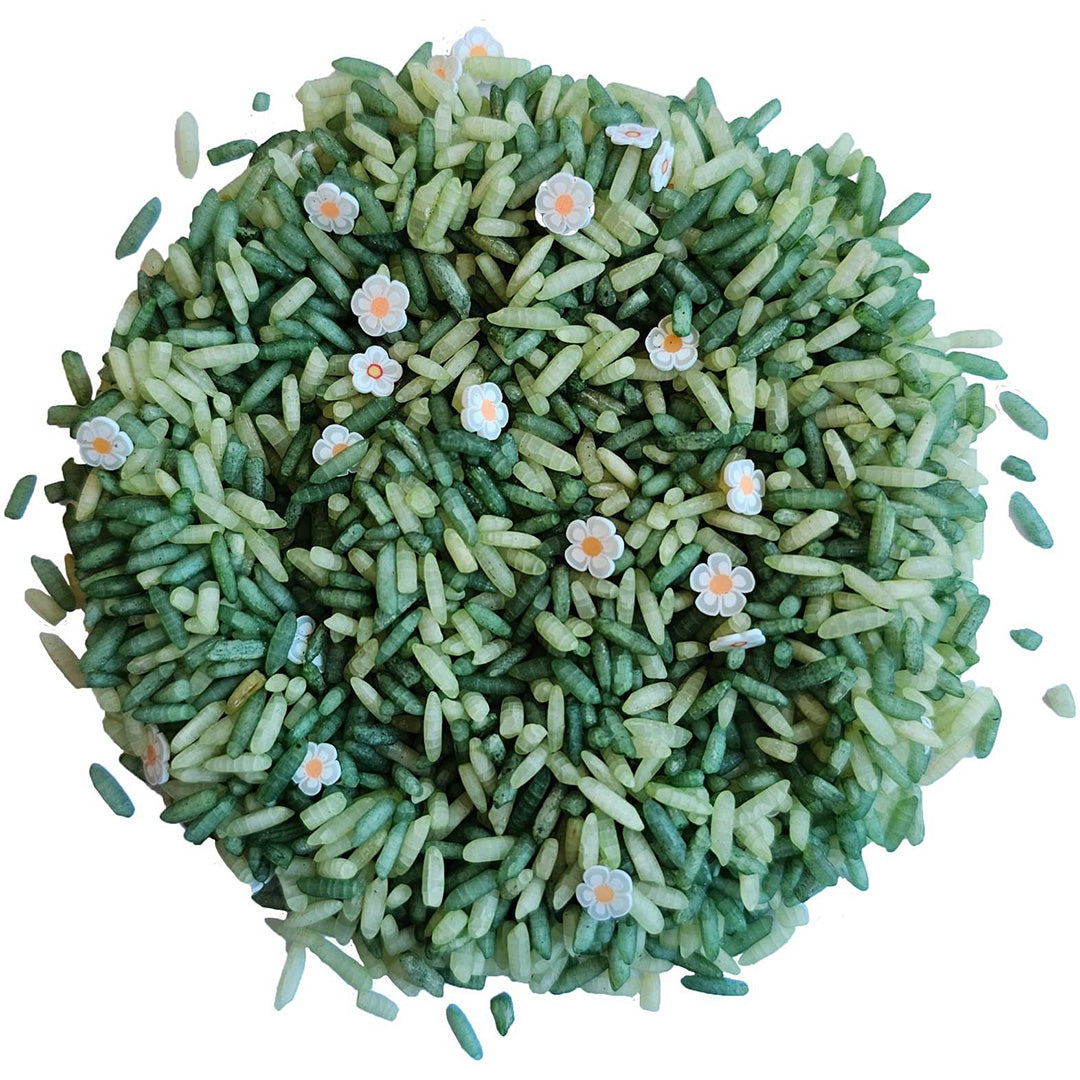 Grennn speelrijst white flower mix, een hoopje groene rijstkorrels met witte bloemetjes.