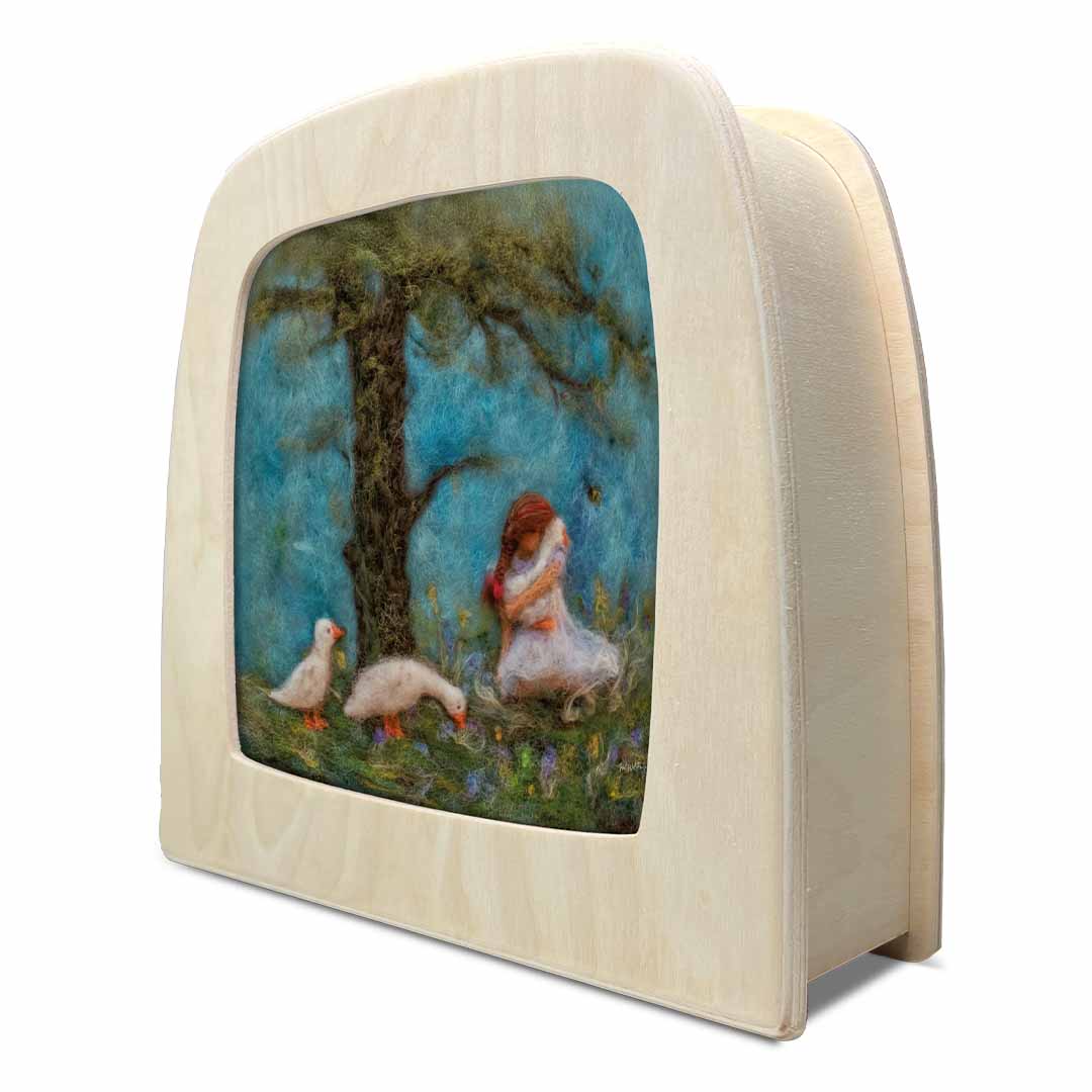 Schuin aanzicht van de toverlux toverplaat 'ganzen knuffels' in een houten frame, met zicht op de zijkant.