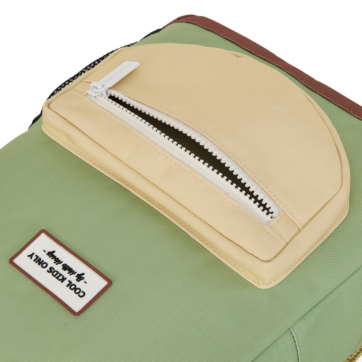 Detail van de Hello Hossy pistache groene schoolrugzak met het beige voorvak en het 'COOL KIDS ONLY' label.