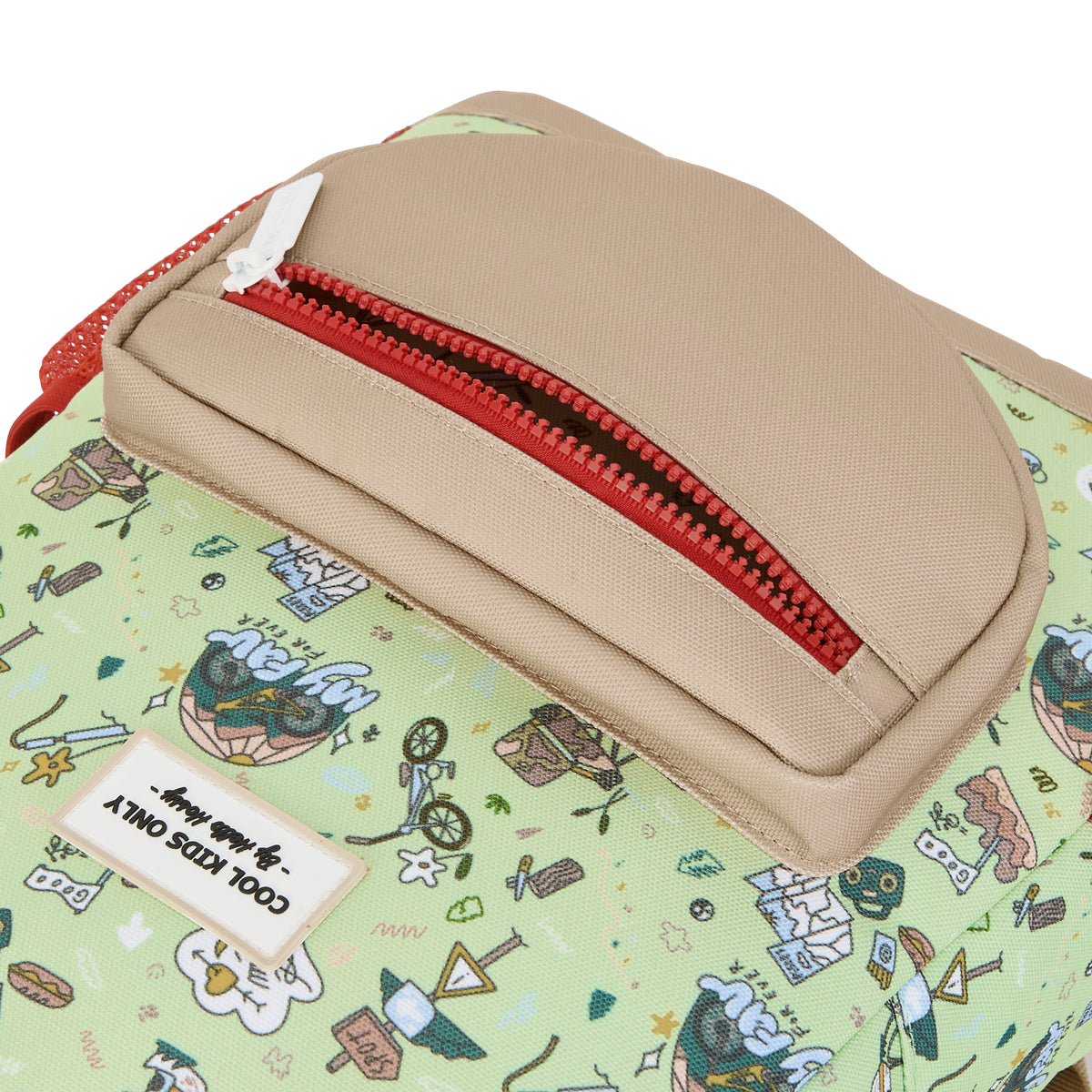 Detail van de hello hossy kinderrugzak met het beige voorvak met rode rits en het groene 'mountain ride' patroon.