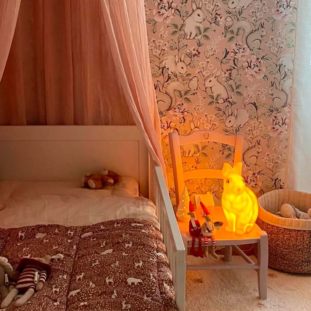 Egmont Toys konijnen nachtlamp die warm licht geeft op een stoel in een kinderkamer.
