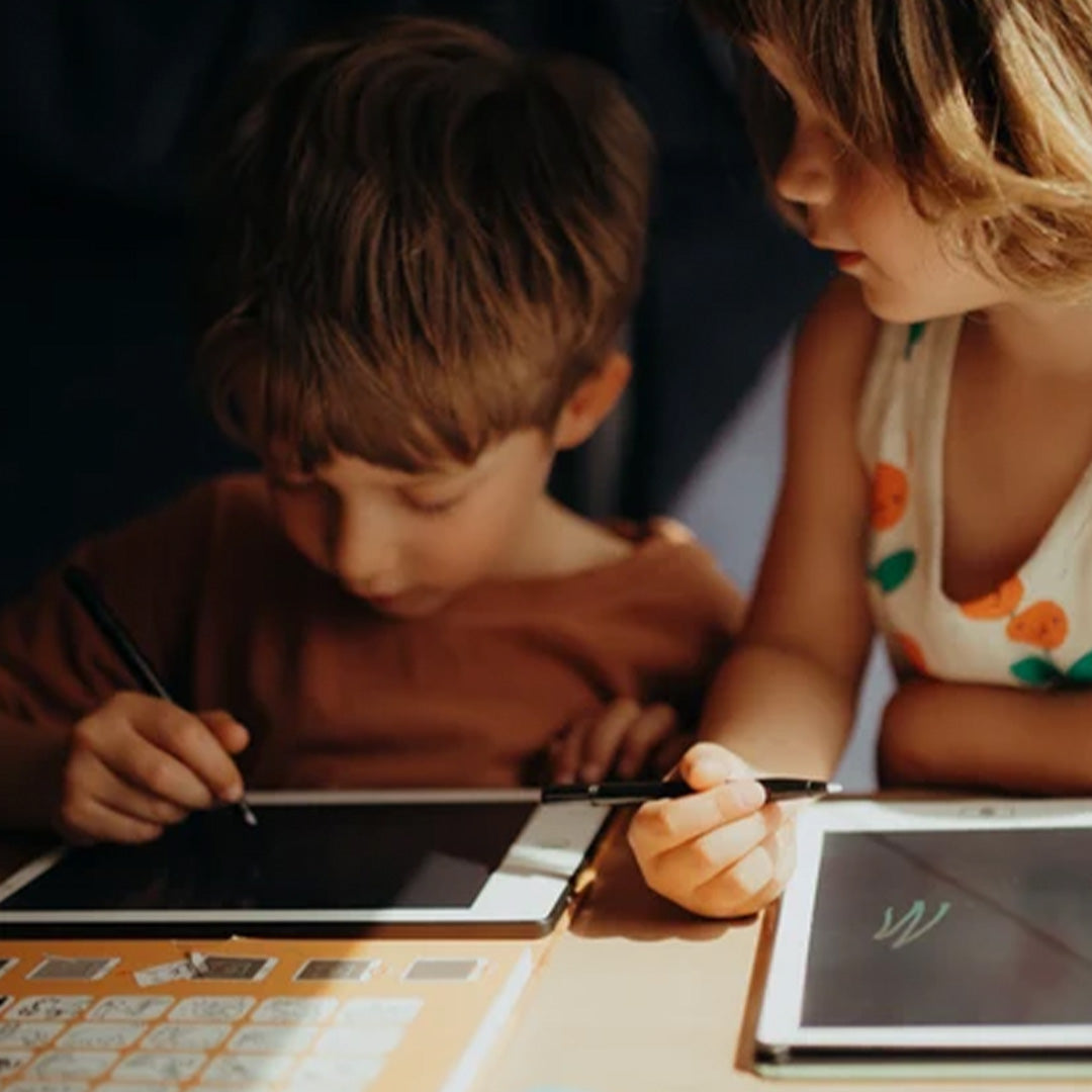 Twee kinderen tekenen met zwarte Kidywolf stylus pennen op Kidydraw mini tekentablets.