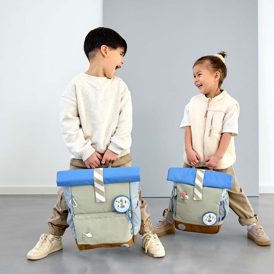 Twee lachende kinderen houden elk een Lässig schoolrugzak sunny explorer vast.